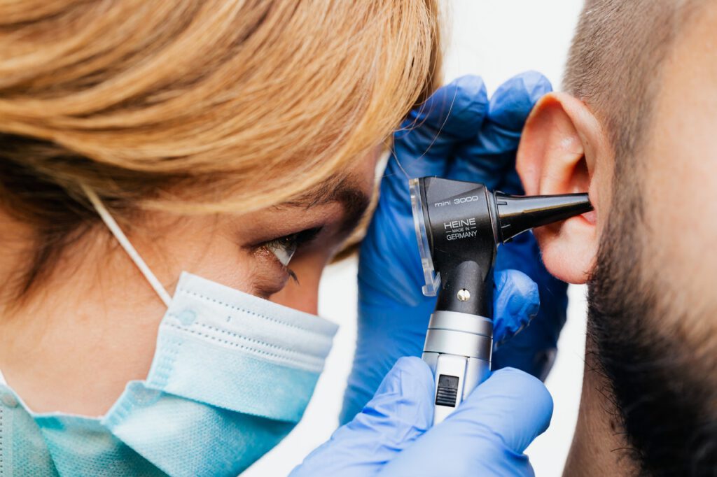 Doctor is checking her's patient's ear
