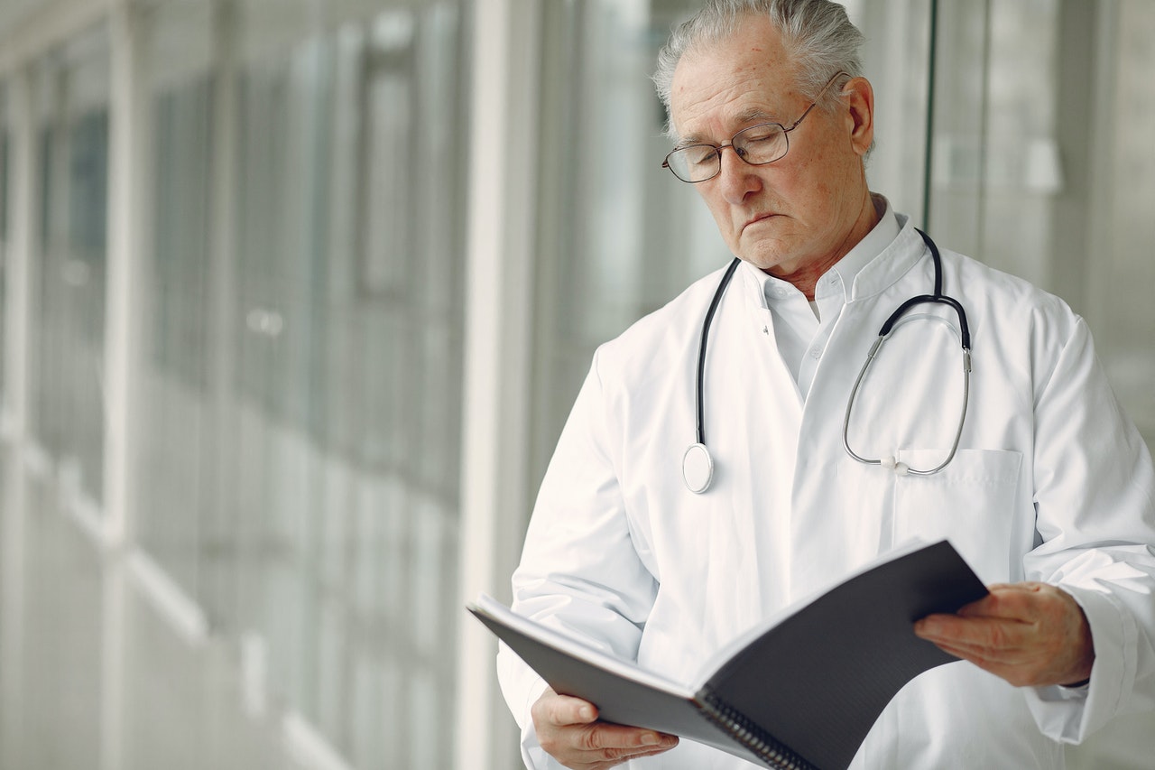 Doctor is looking at his patient's history card