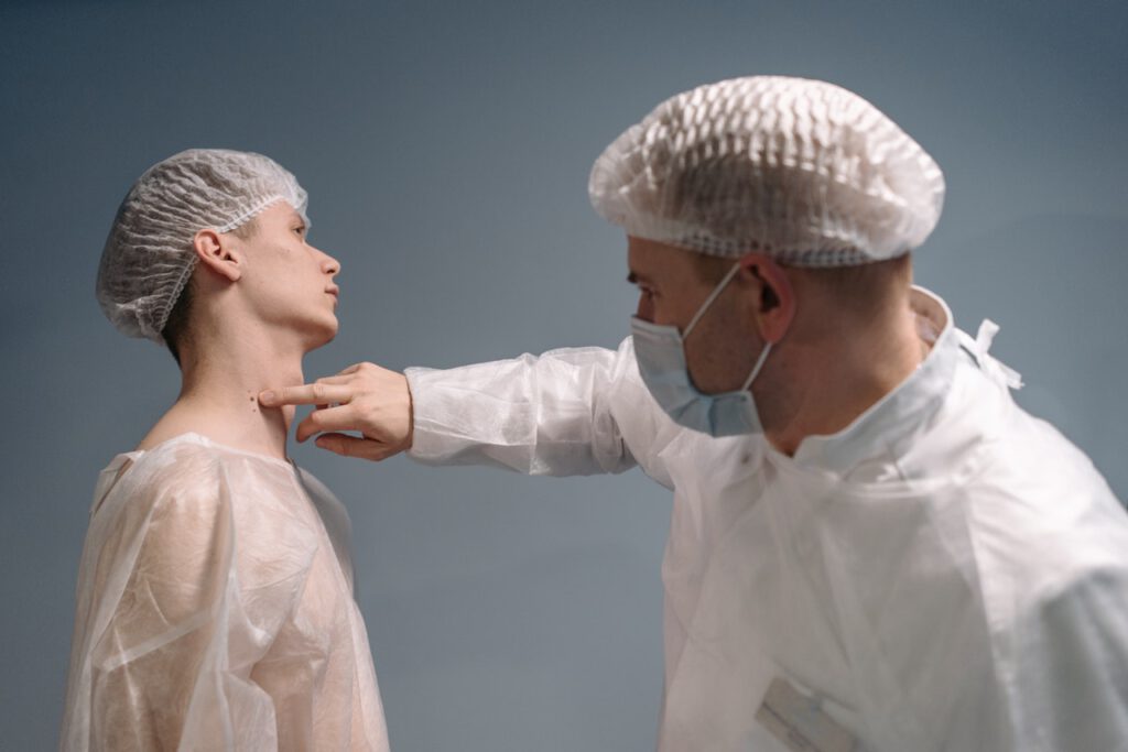 Doctor is pointing on the patient's neck with moles