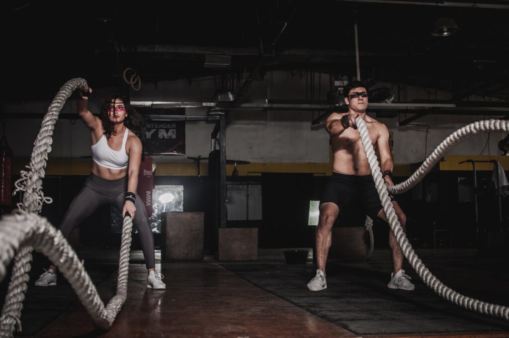 Woman and man are working out together at the gym